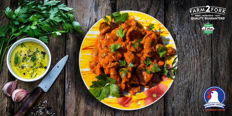 Plated delicious chicken gizzards with dip alongside coriander,2 garlic cloves and a knife | Country Choice Chicken Gizzards